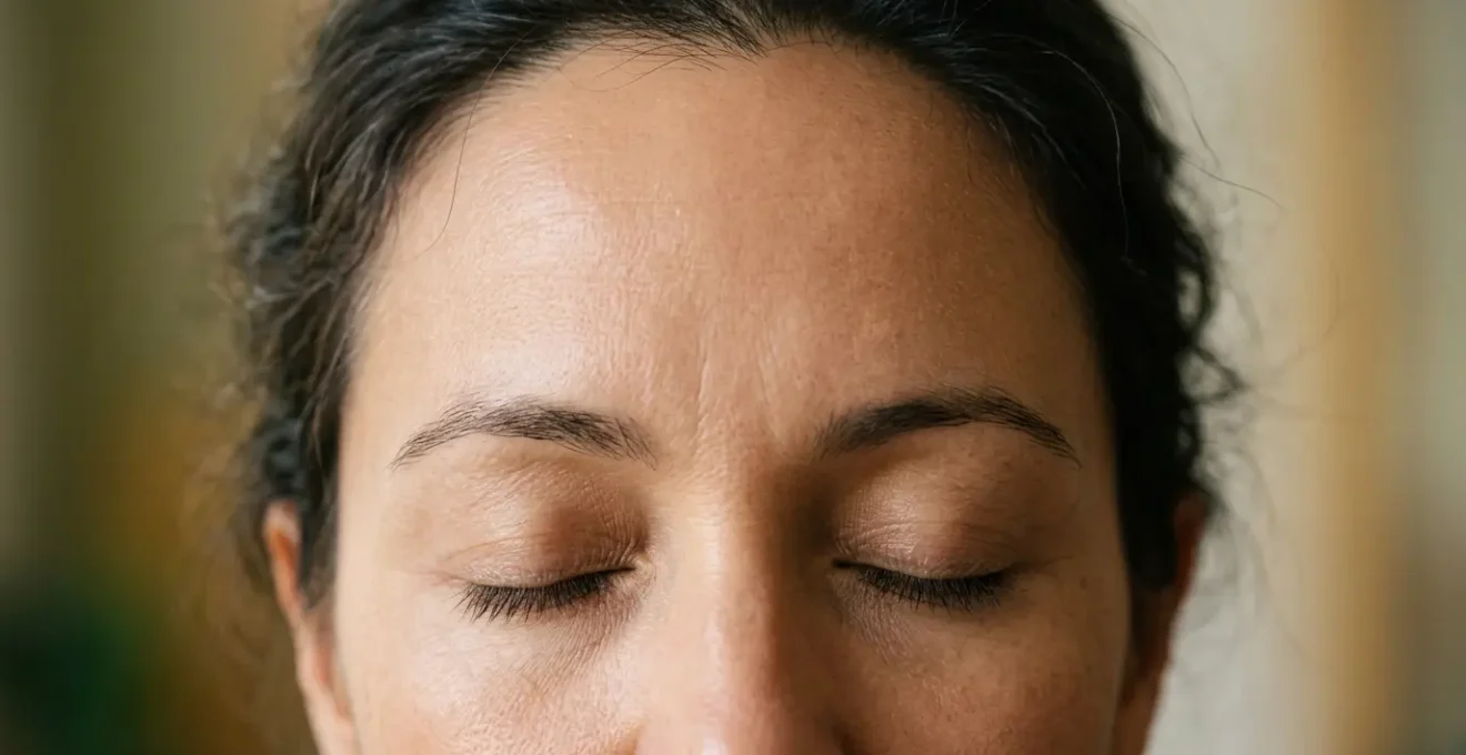 Primo piano di una fronte distesa con espressione naturale e serena, illuminazione morbida che evidenzia la texture della pelle