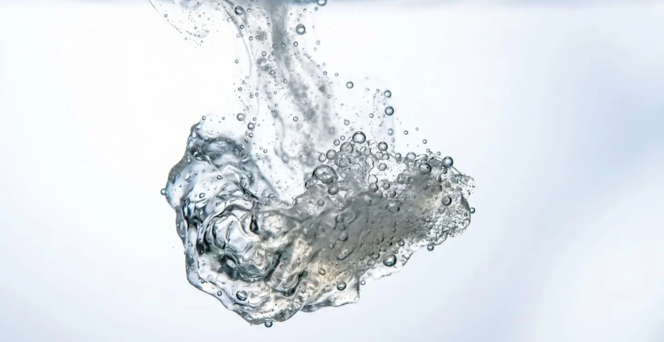 Rappresentazione macro di cristalli che si dissolvono in acqua, metafora del processo di scioglimento del filler